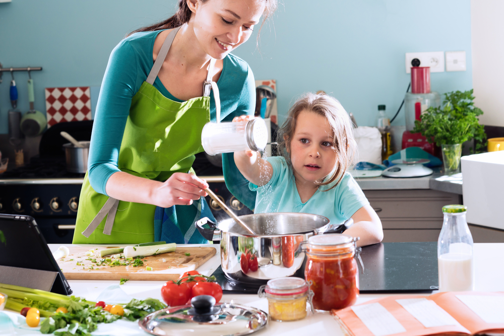 A mom and daughter cooking with salt