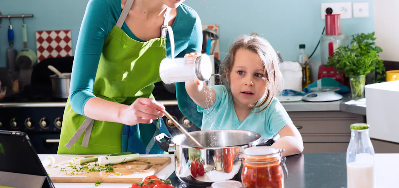 A mom and daughter cooking with salt