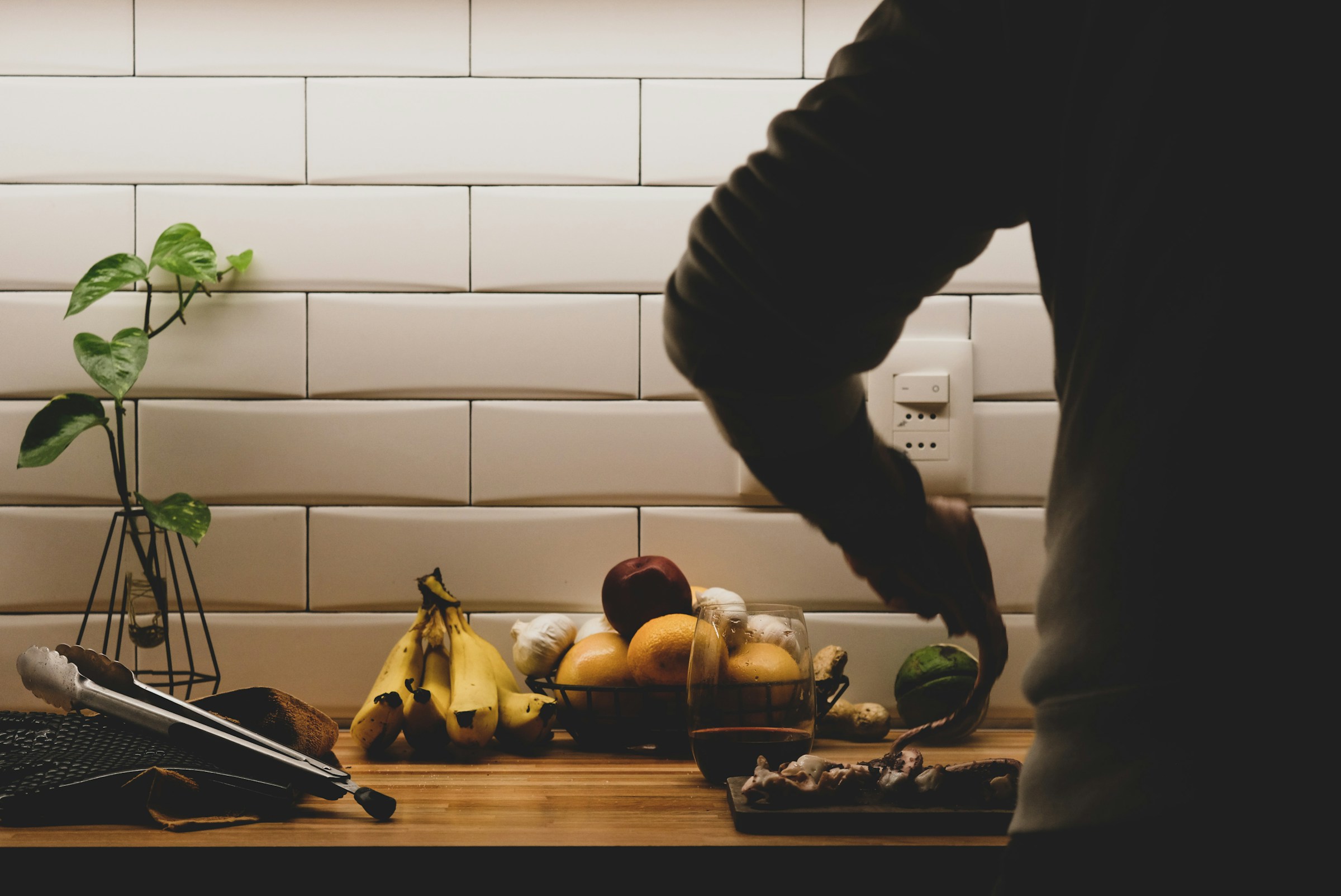 A man preparing a low carb food including eggs, fish, nuts, cheese, and leafy greens