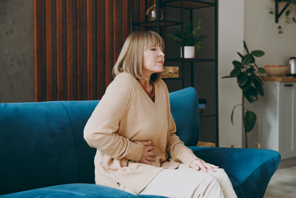 A lady feeling bloated after a meal