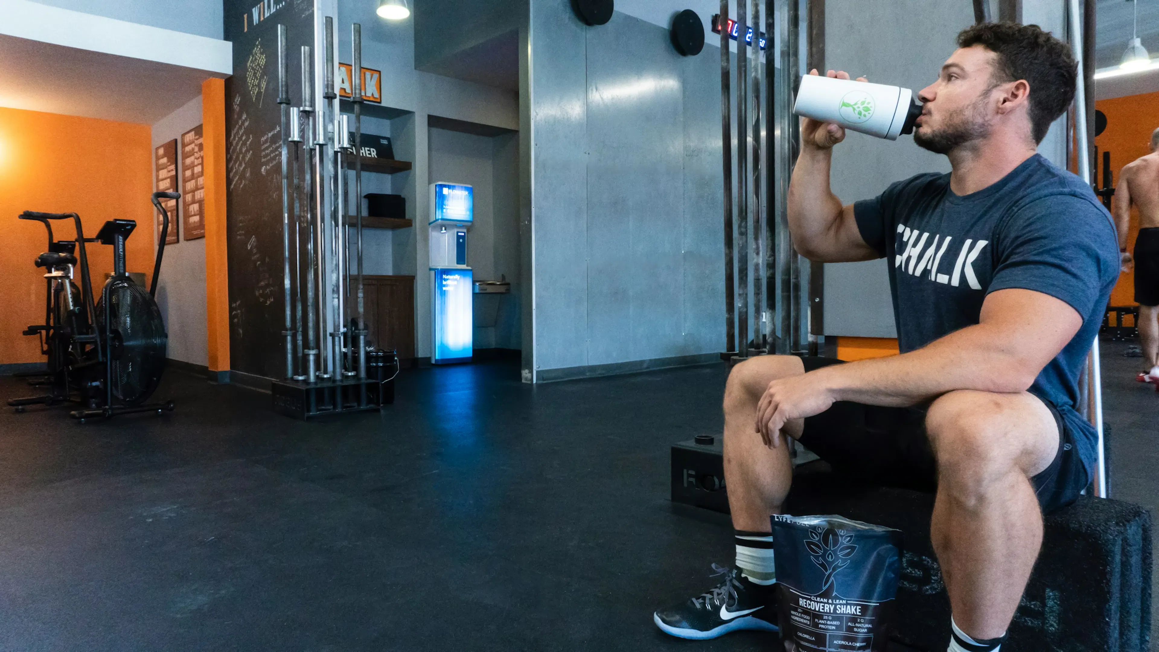 A person taking protein shake in the gym