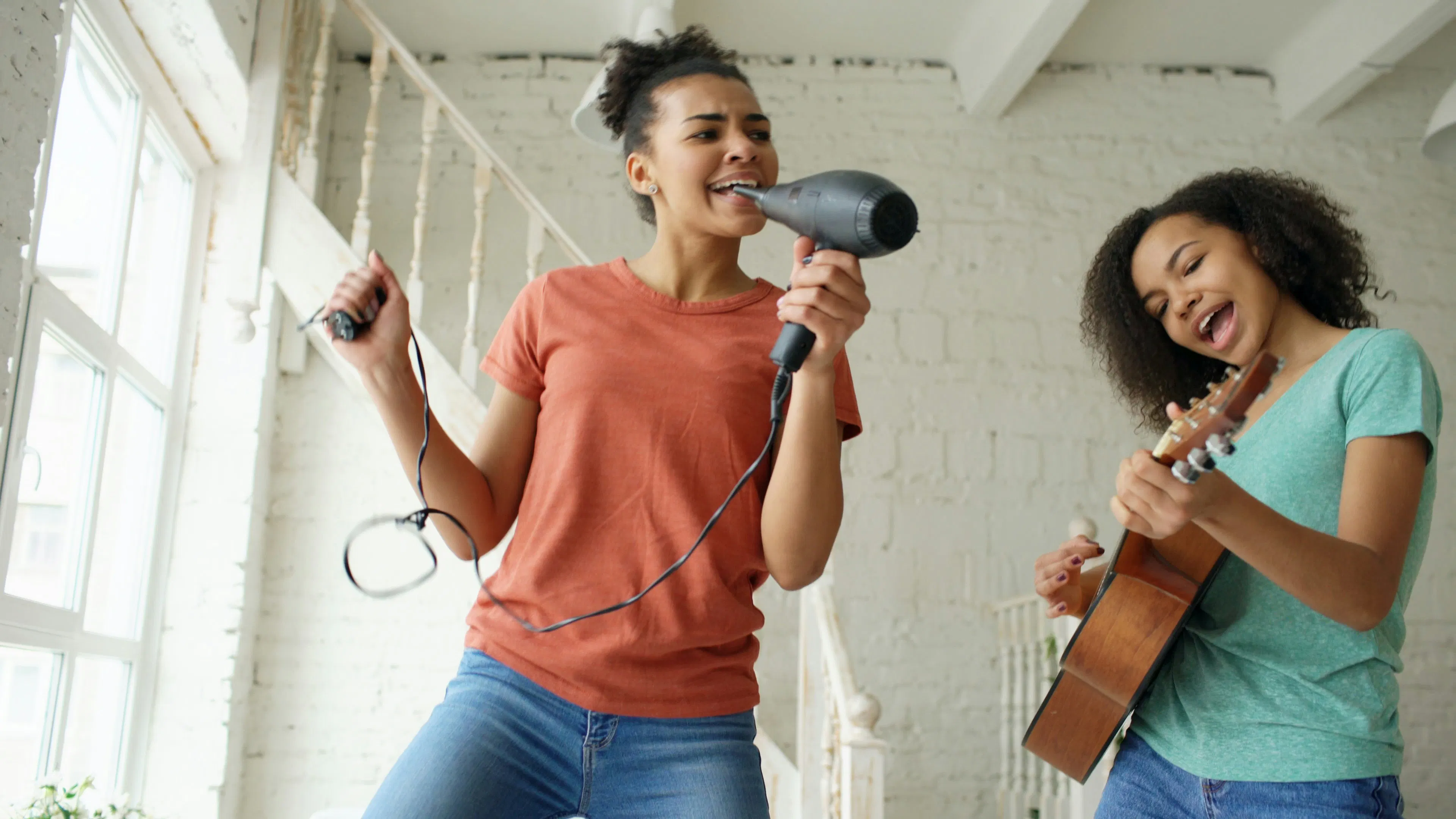 An image showing to sisters having fun singing