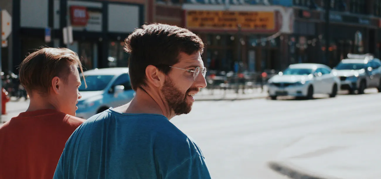 An image showing two adult men walking on the street