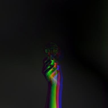 Mano agarrando una bombilla con filtro tricolor