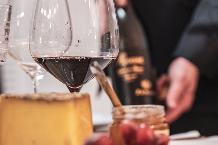 Mit Käse, Trauben und Rotwein angerichteter Tisch.