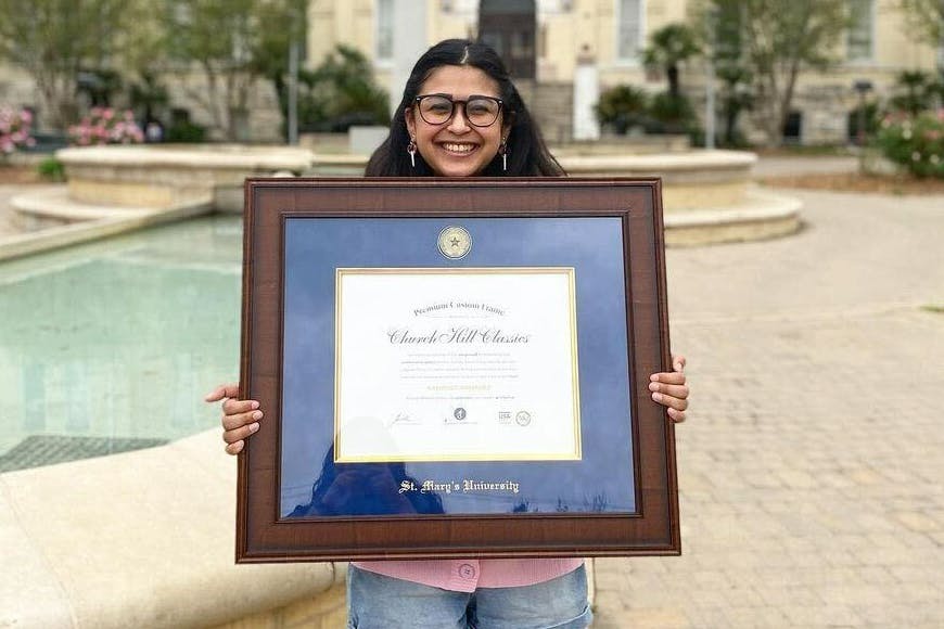 graduate holding a St Marys University Diploma Frame