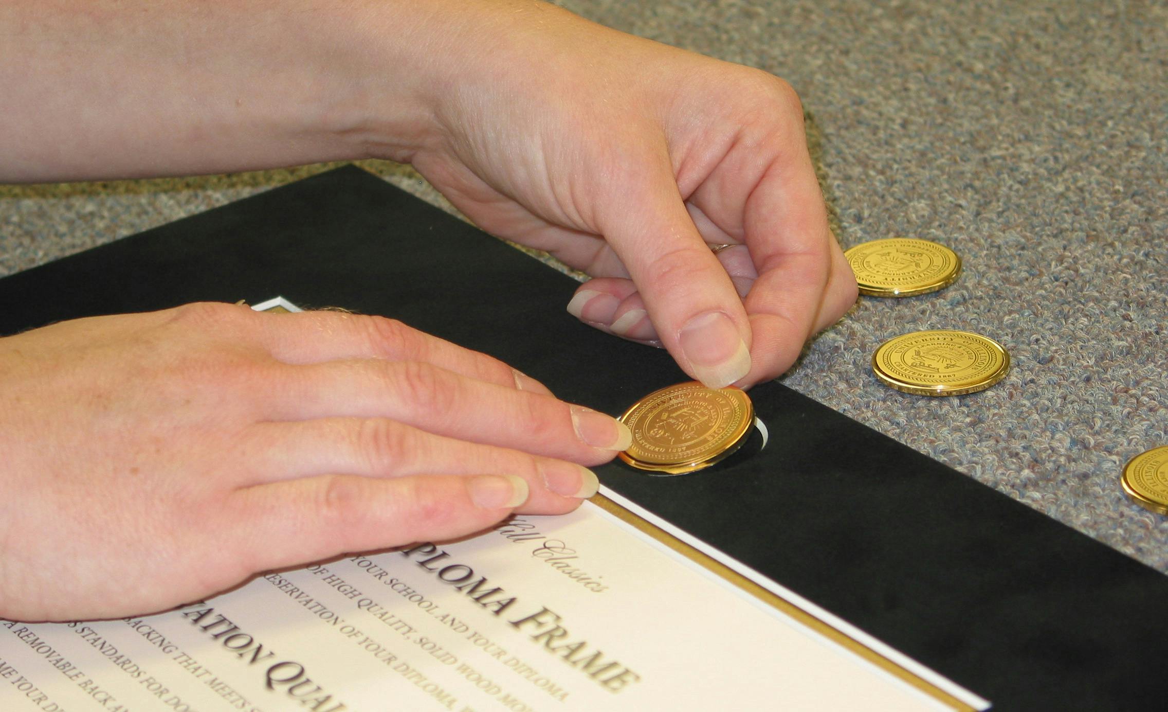 Inserting medallion on diploma frame