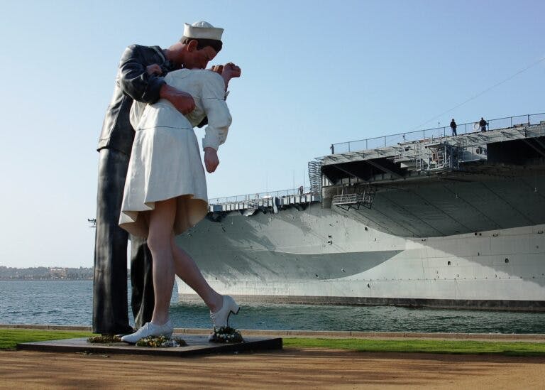 "The Kiss" statue with the USS Midway Museum behind
