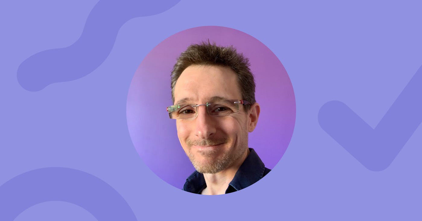 Headshot. Matt, a writer and novelist, wearing rectangular glasses smiles warmly against a purple gradient background.
