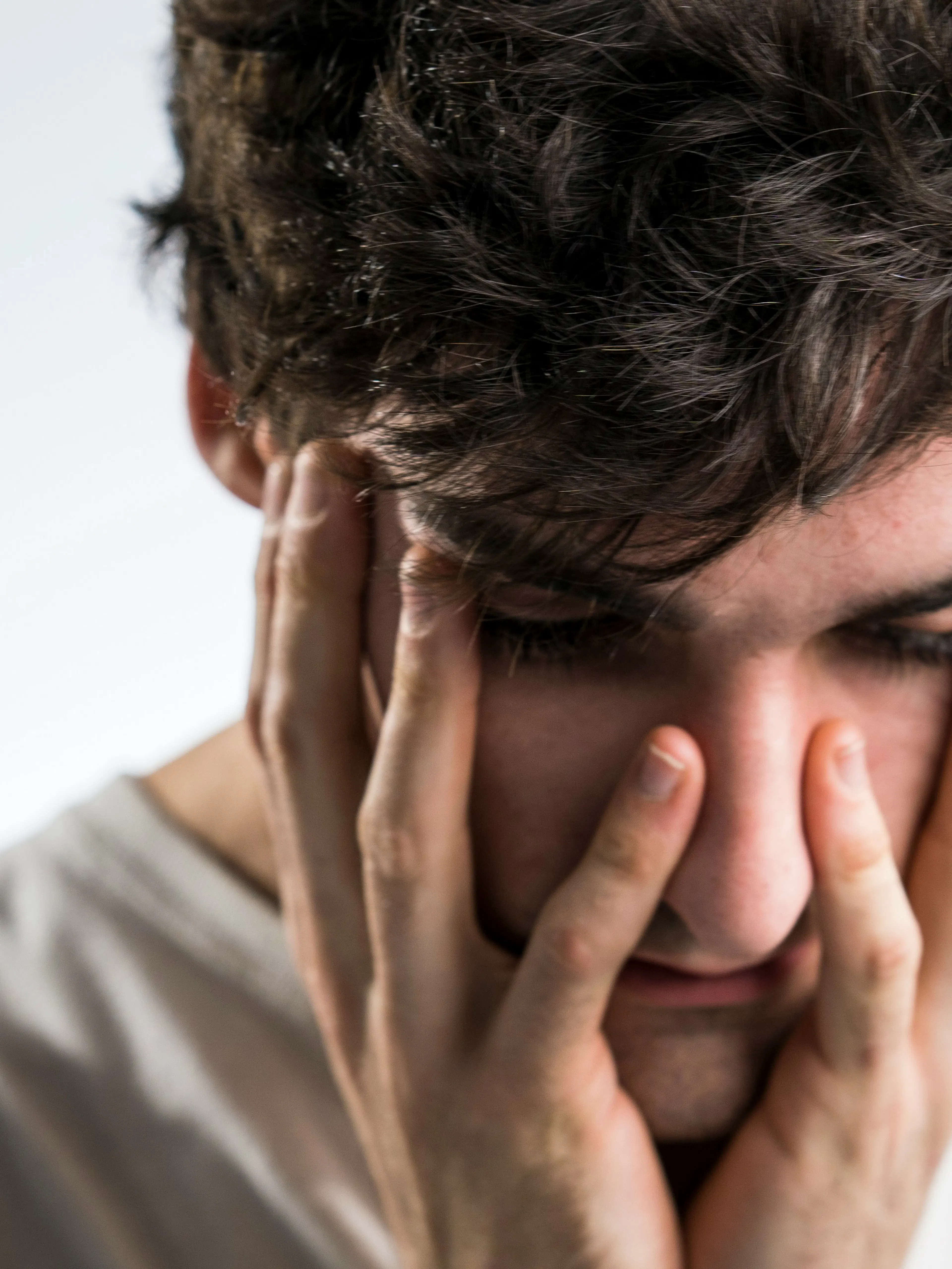 man touching face with both hands