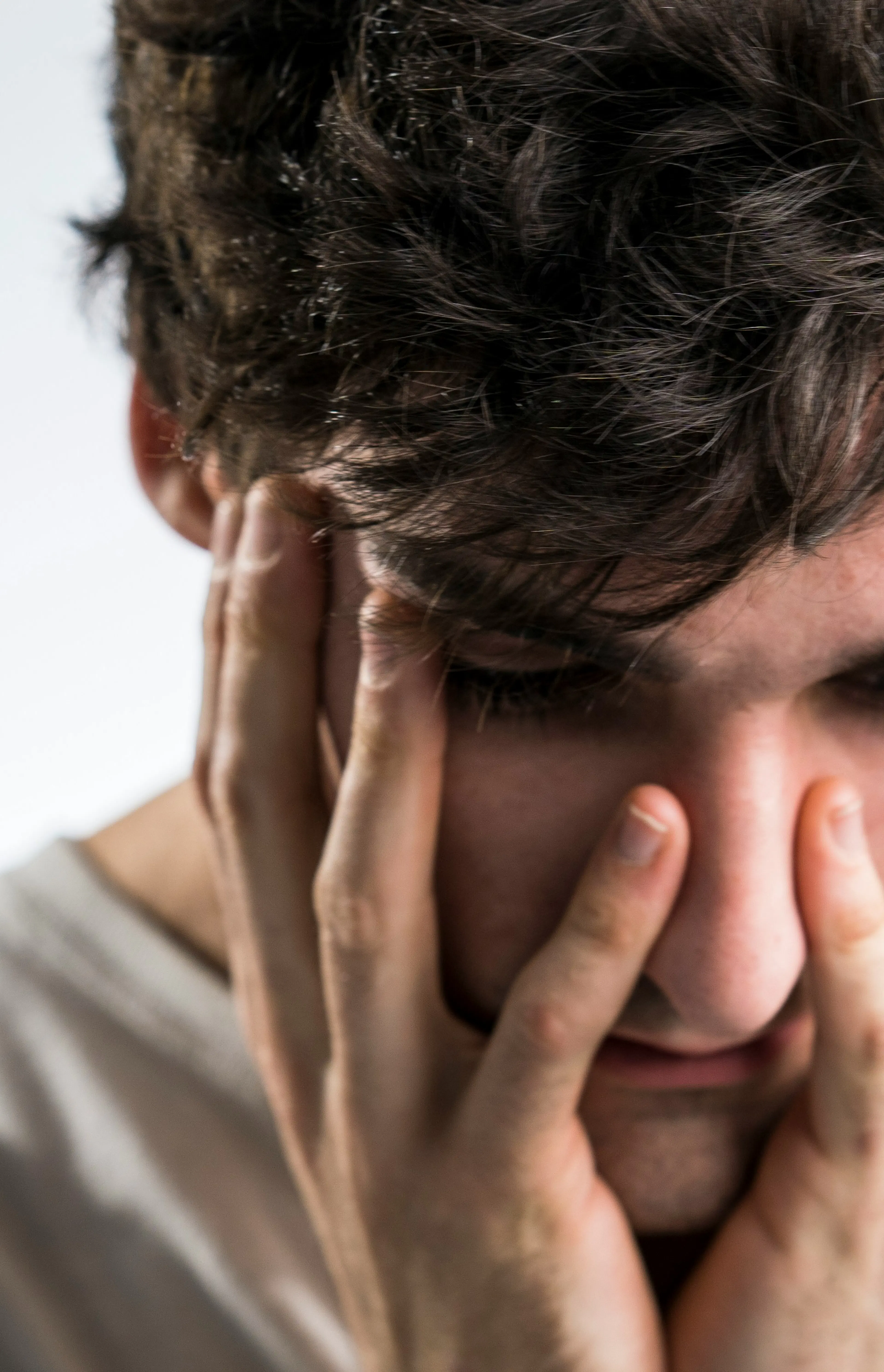 man touching face with both hands