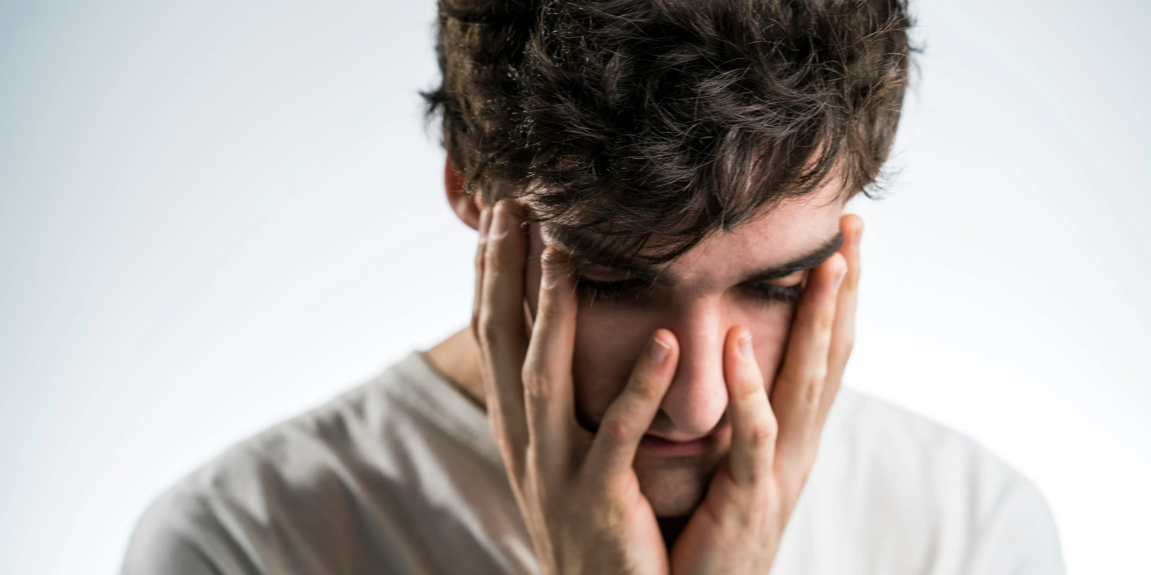 man touching face with both hands