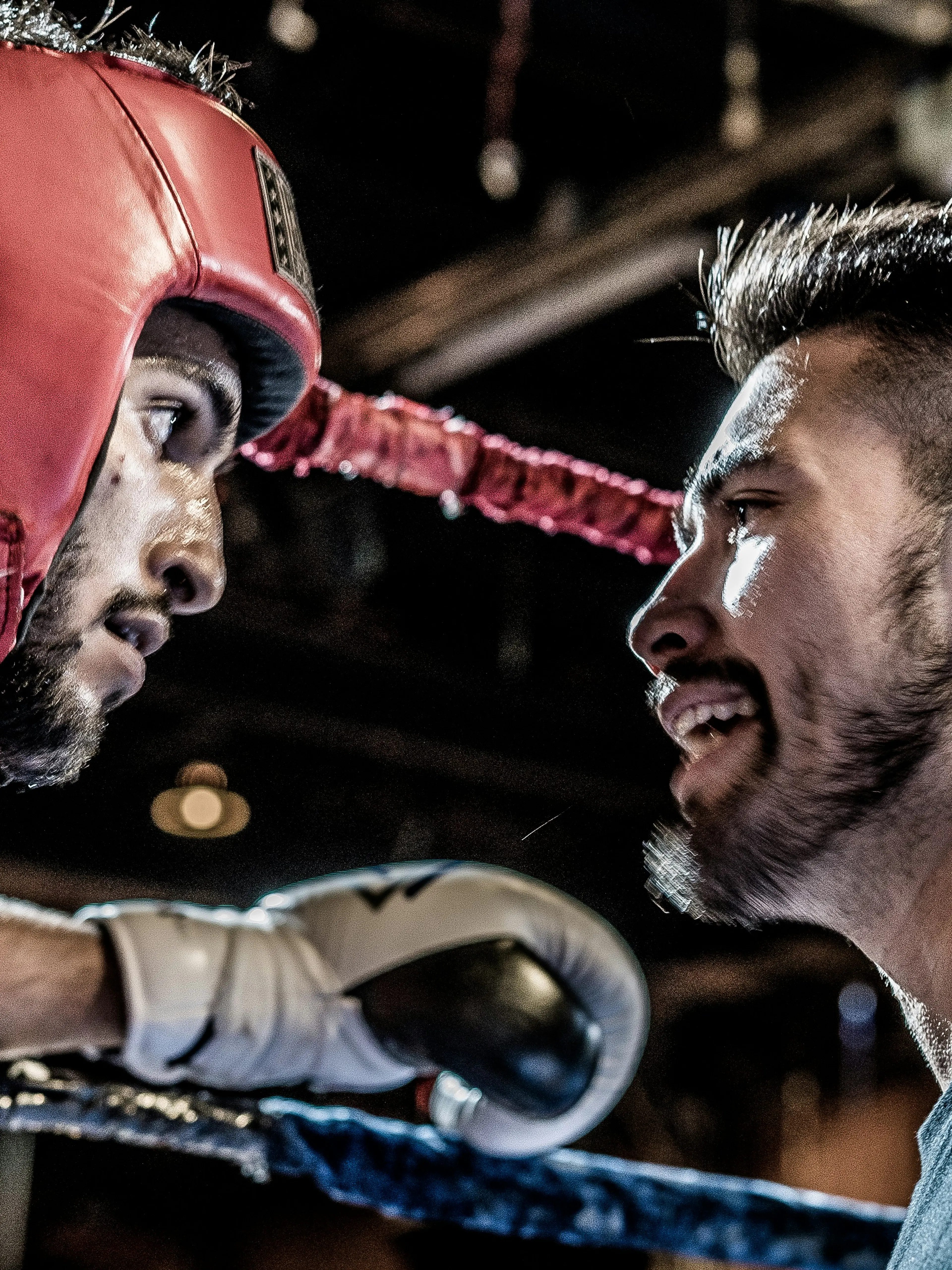 man in black talking to boxer inside ring
