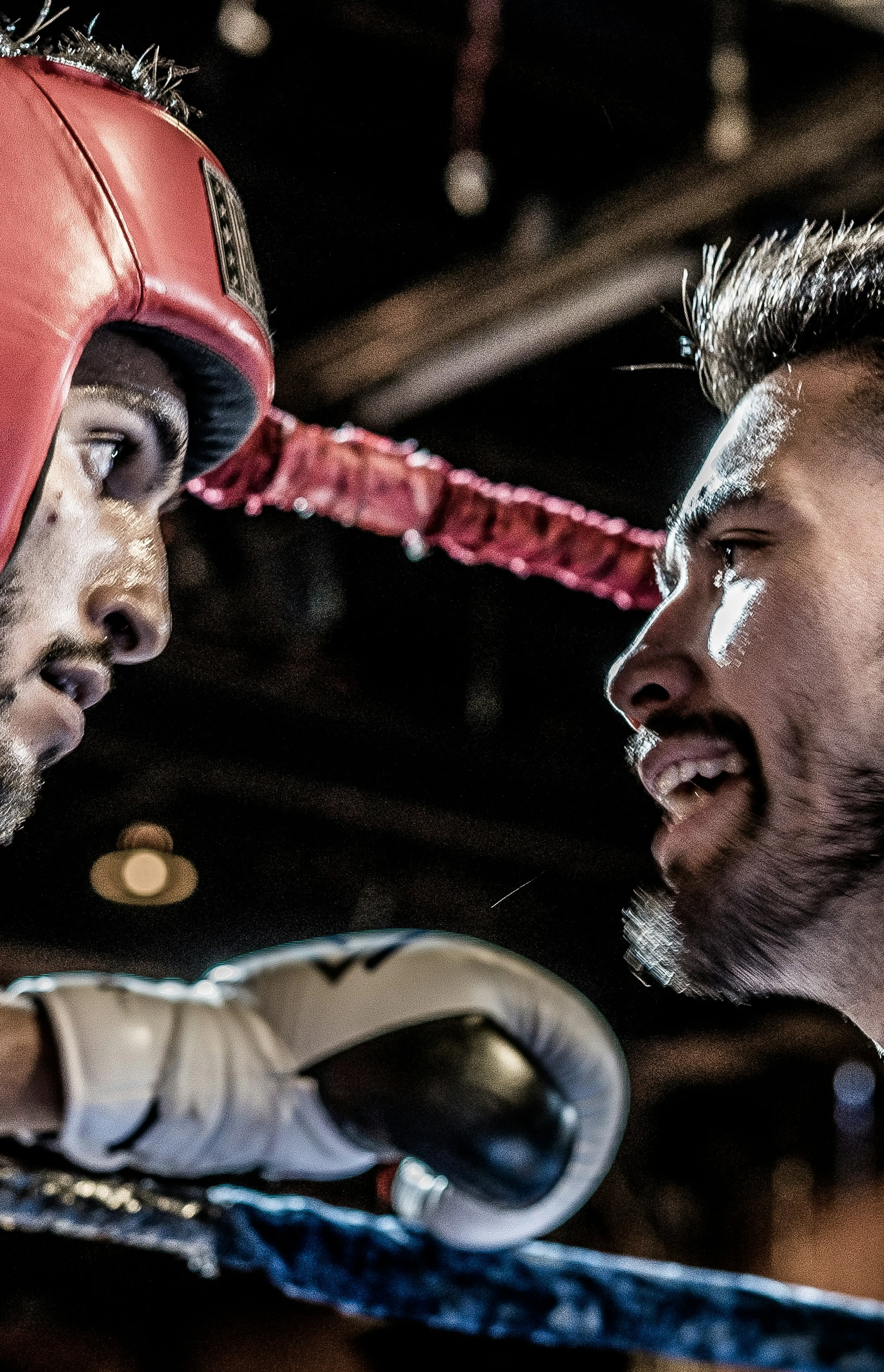 man in black talking to boxer inside ring