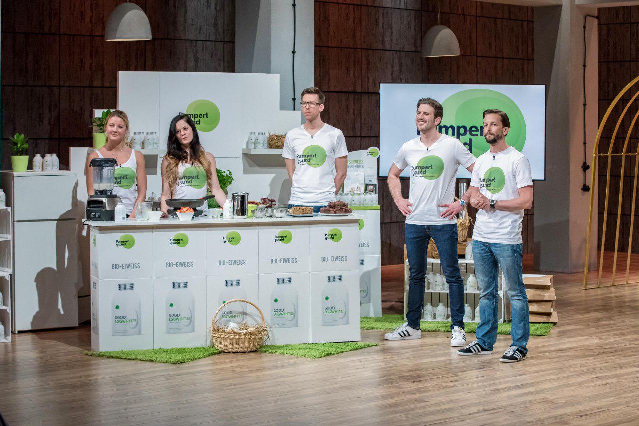 Pumperlgsund team of five people standing on stage presenting their egg white product and health food brand