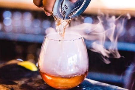 A glass of smoked cocktail.