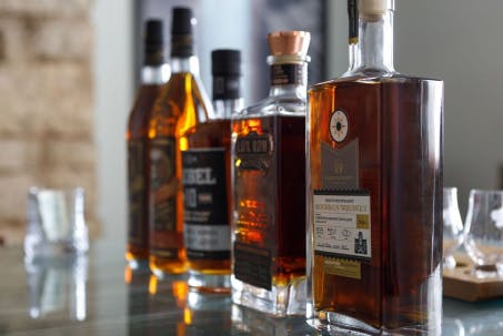 A selection of various bourbon bottles, each with distinct labels and unique designs.