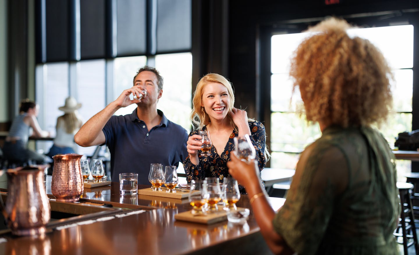 Three adults enjoying their whiskey at Lux Row Distillery