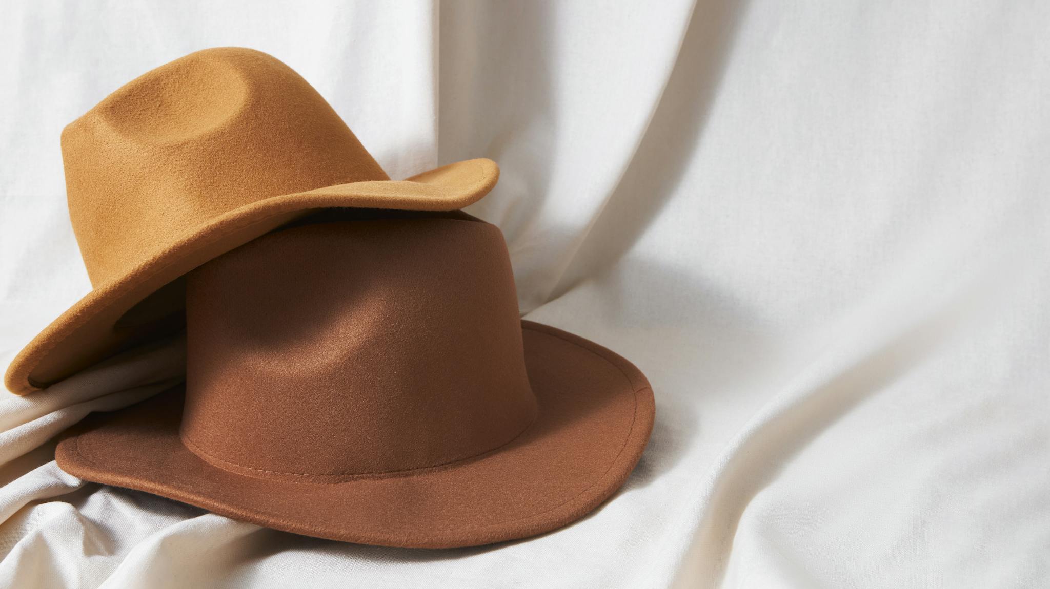 Two brown hats with a white background.
