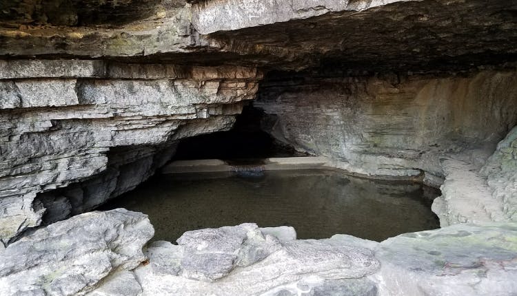 Cave Spring Hollow, located on the Jack Daniel's property in Lynchburg, Tennessee, is where the natural spring water essential to the distillery's whiskey-making process originates, symbolizing the brand's craftsmanship and history.