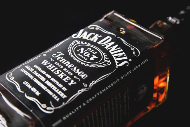 A closeup shot of a Jack Daniel's bottle against a black background.