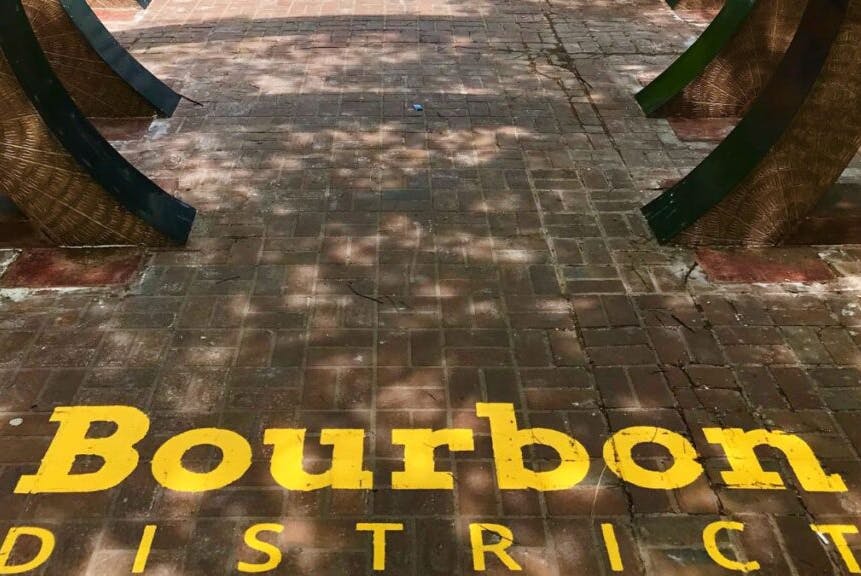 Louisville's Bourbon District featuring the distinctive yellow "Bourbon District" lettering painted on the pavement.