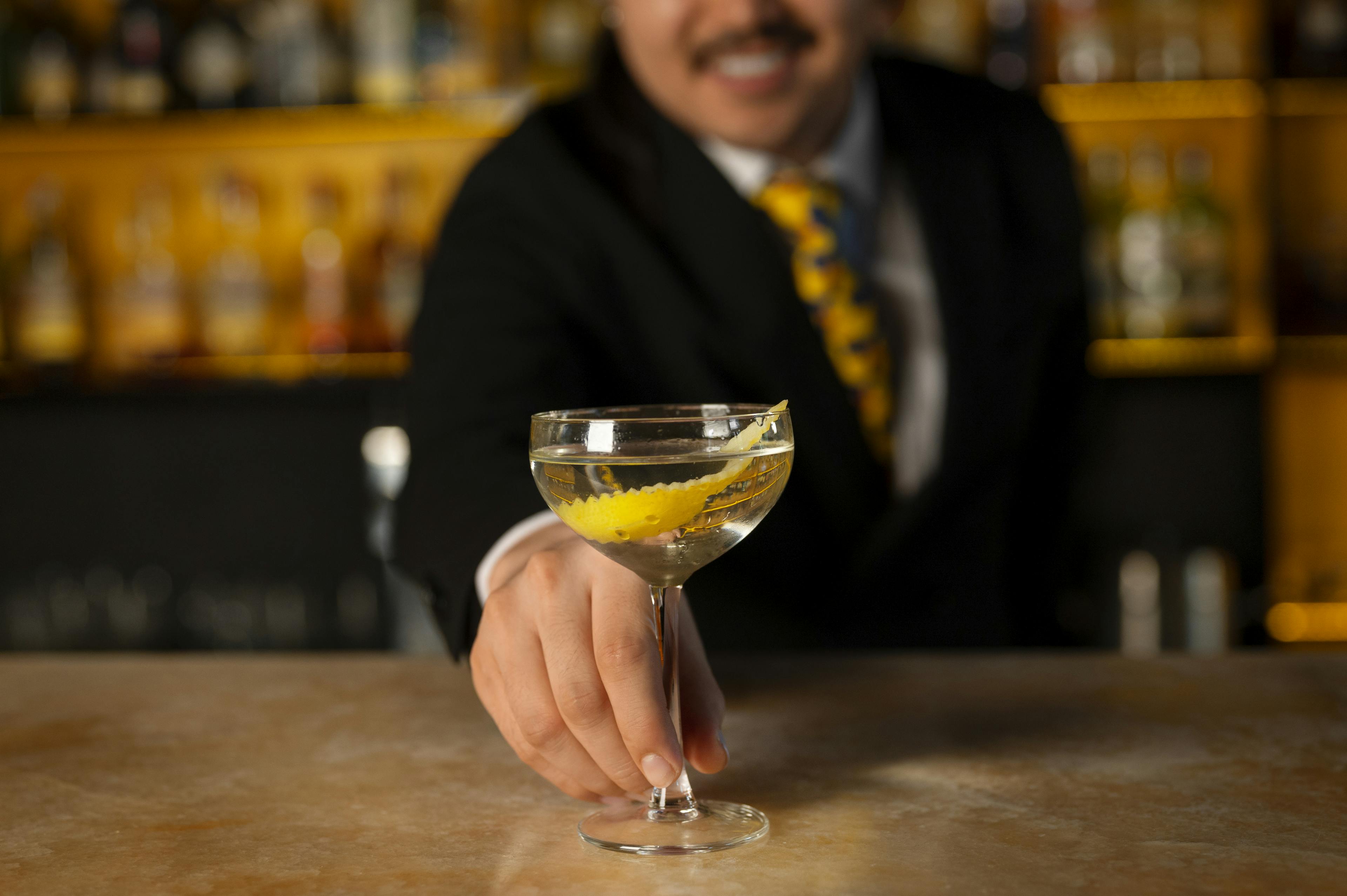 A man at a bar serving a drink.