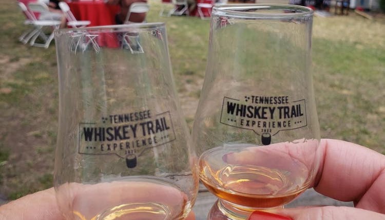 Two whiskey glasses side by side, each etched with the Tennessee Whiskey Trail logo.