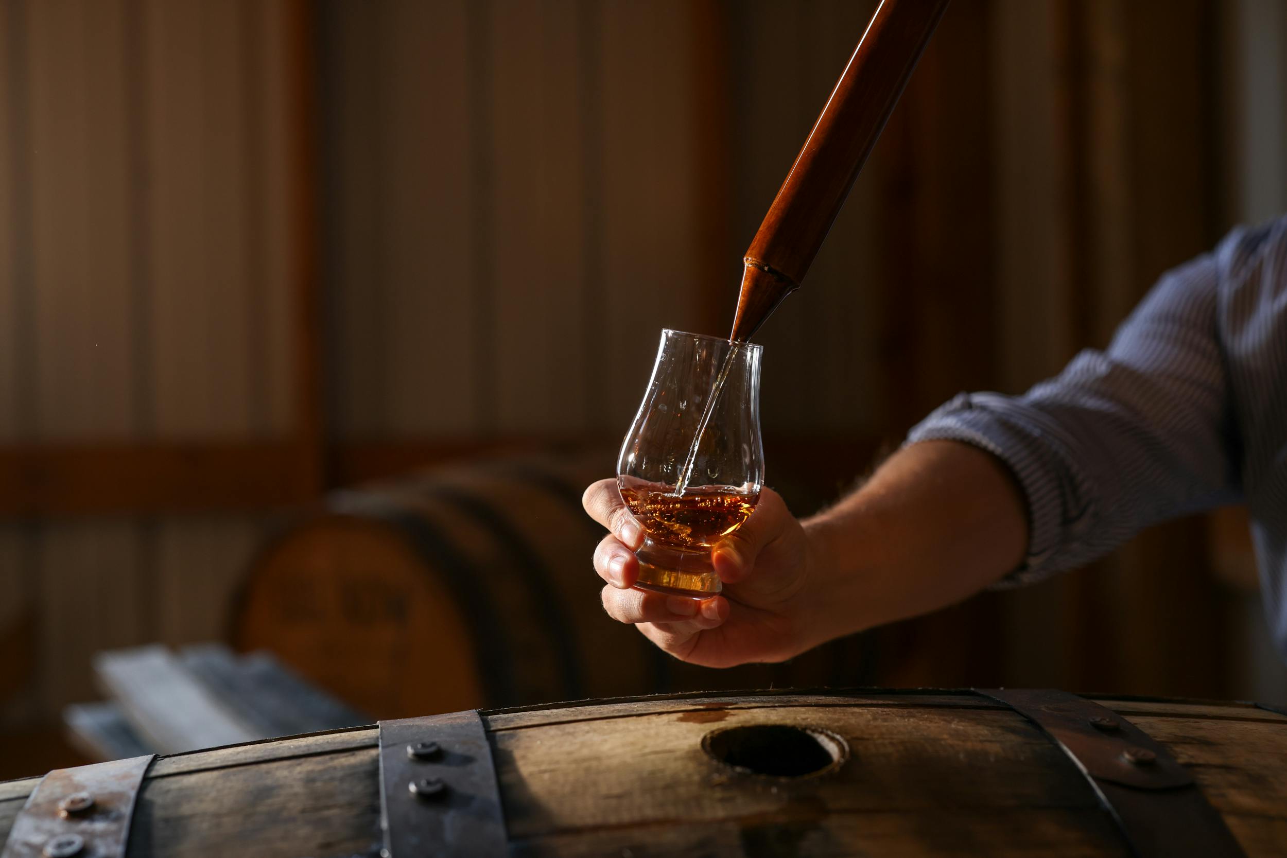 Bourbon being poured into a glass during a barrel thieving experience