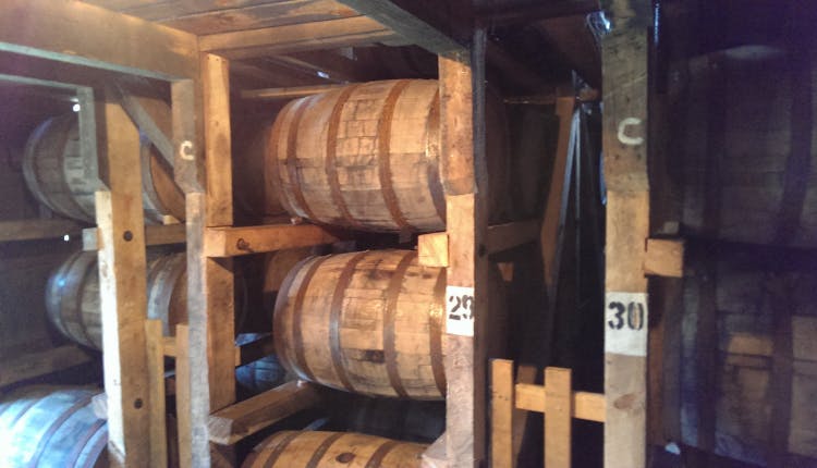 Wooden bourbon barrels stacked for aging.