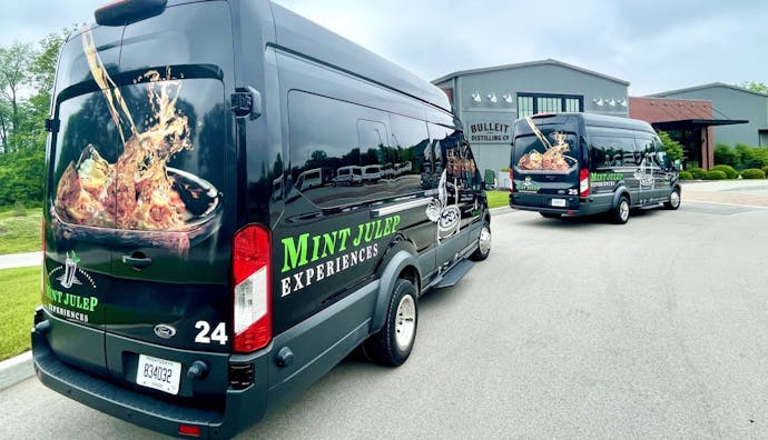 Two Mint Julep Experiences luxury vehicles parked at the Bulleit Distillery premises.
