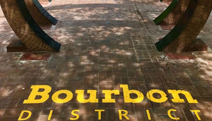 Louisville's Bourbon District featuring the distinctive yellow "Bourbon District" lettering painted on the pavement.
