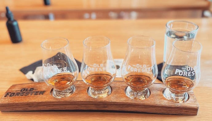 A set of drinking glasses filled with samples of Old Forester bourbon.