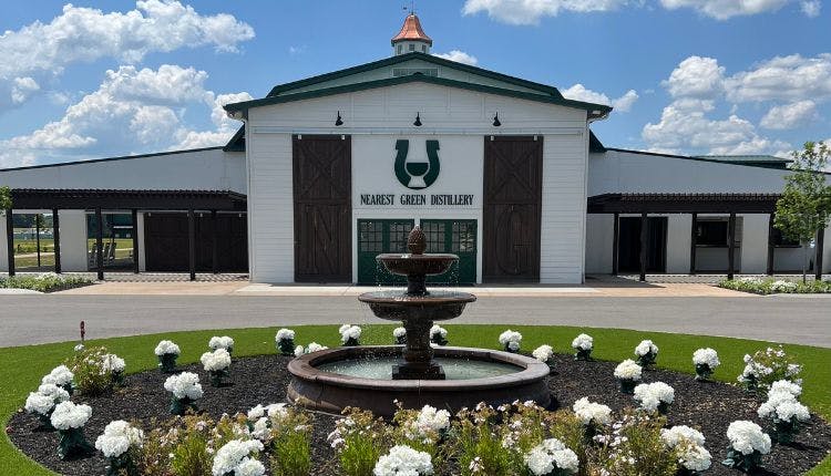 A front view of Nearest Green Distillery, showcasing the building and surrounding landscape.
