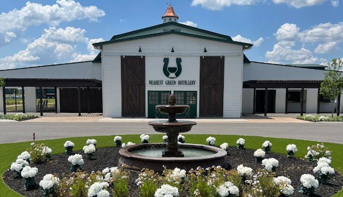 A front view of Nearest Green Distillery, showcasing the building and surrounding landscape.
