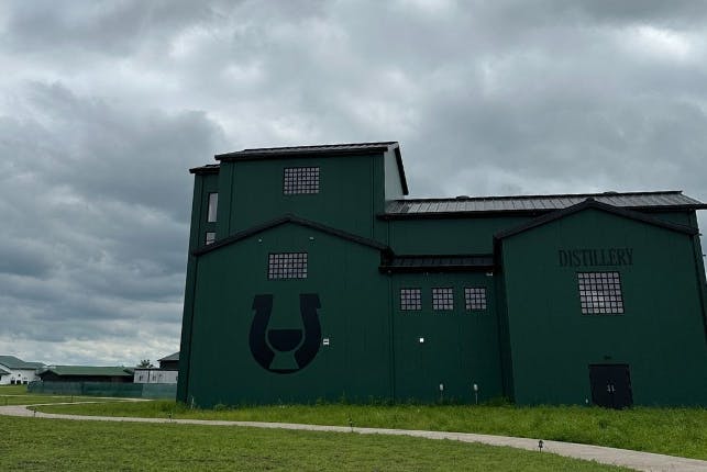 An exterior view of Uncle Nearest Distillery, featuring its dark green paint.