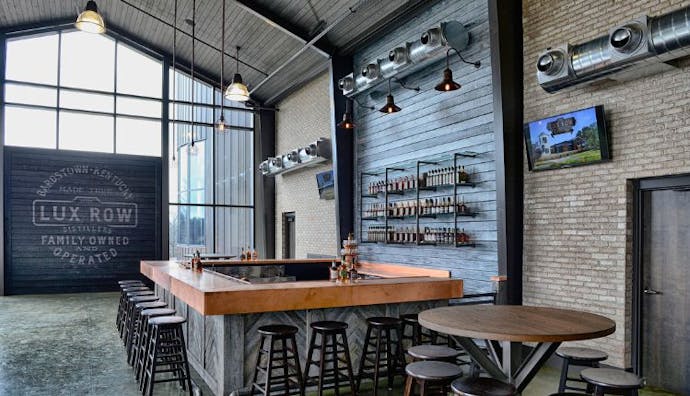 The interior of Lux Row Distillery, featuring a bar with seats for guests.