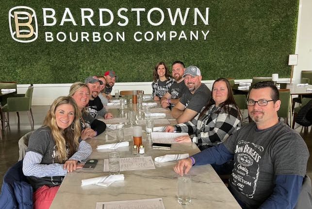 Tourists seated at a table at Bardstown Bourbon Company, enjoying their visit.