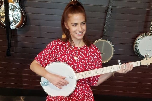 A woman happily playing a banjo.