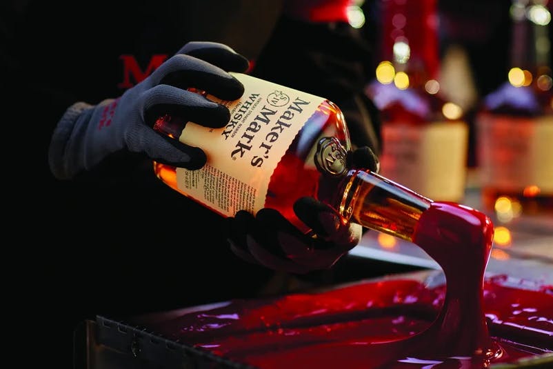 Customers dip Maker's Mark bottles into red wax