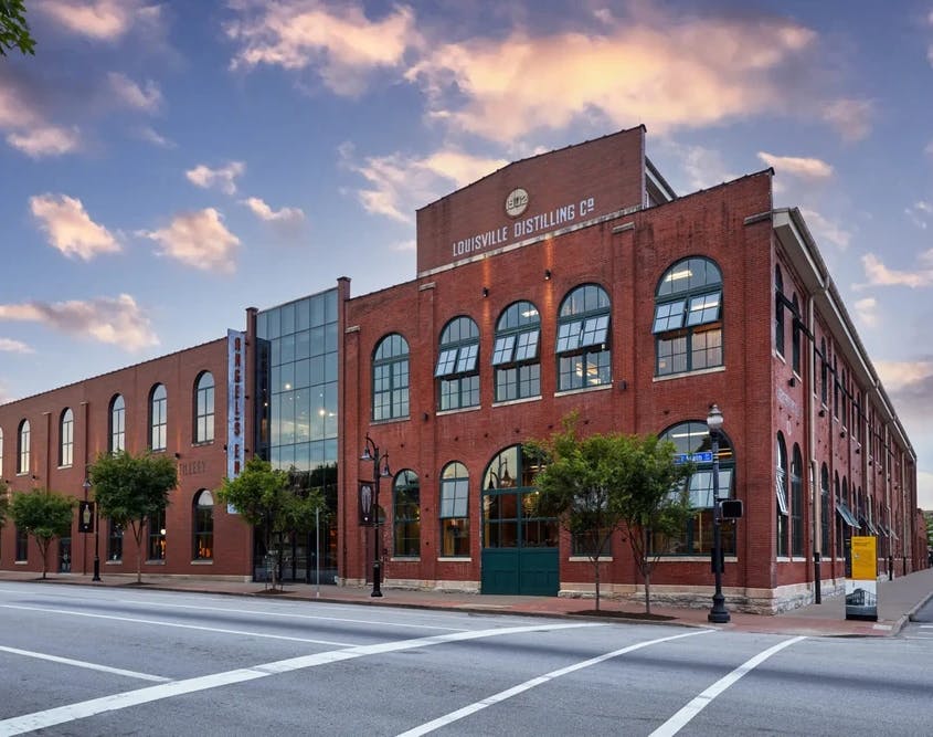 An exterior view of Angel's Envy Distillery, featuring its brick facade and entrance signage.