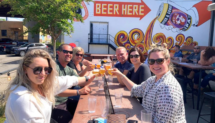 A group of tourists at a table enjoying their beer.
