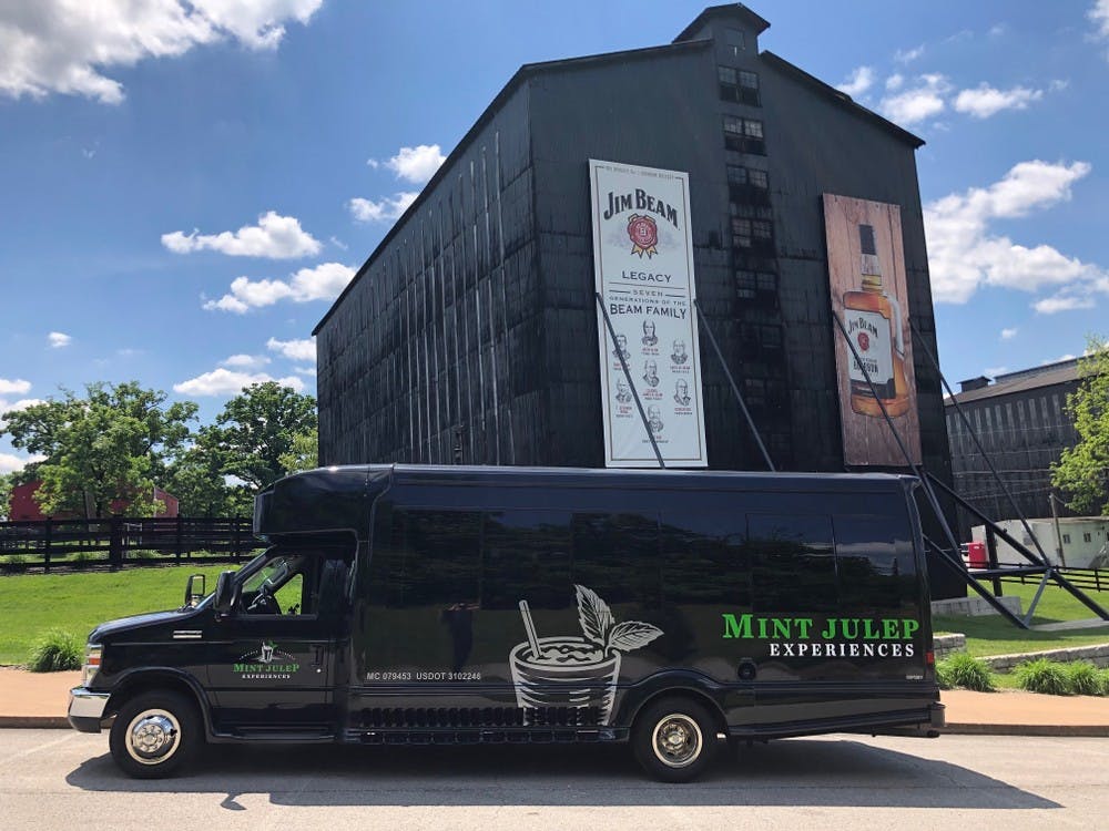 A Mint Julep Experiences luxury transportation parked in front of Jim Beam Distillery 
