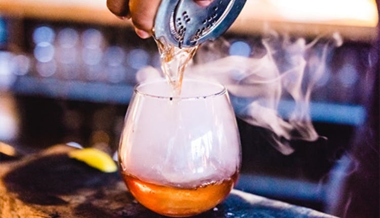 A glass of smoked cocktail.