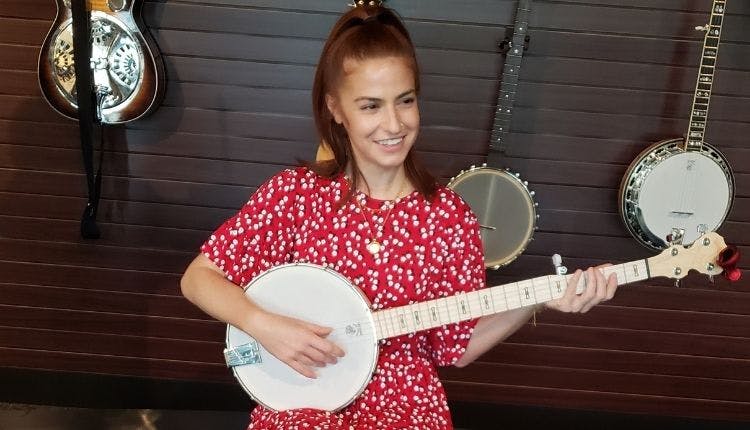 A woman playfully strumming a banjo.