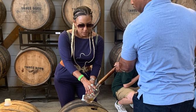 A woman engaged in a bourbon thieving experience by Mint Julep Eperiences.