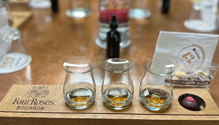 A tray holding three tasting glasses filled with Four Roses Bourbon, arranged for a sampling experience.