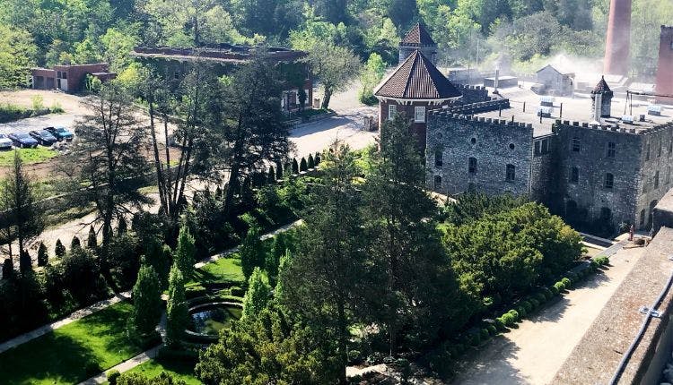 The exterior of Castle & Key Distillery, nestled amid lush greenery and natural surroundings.