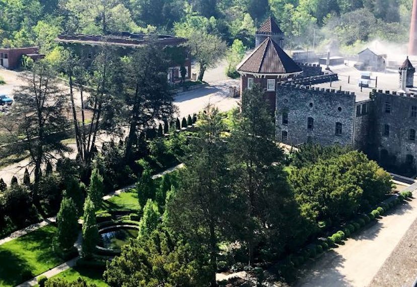 The exterior of Castle & Key Distillery, nestled amid lush greenery and natural surroundings.