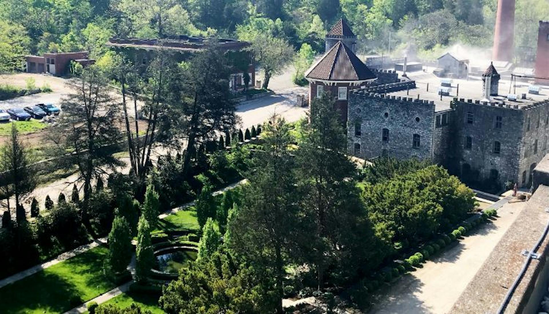 The exterior of Castle & Key Distillery, nestled amid lush greenery and natural surroundings.